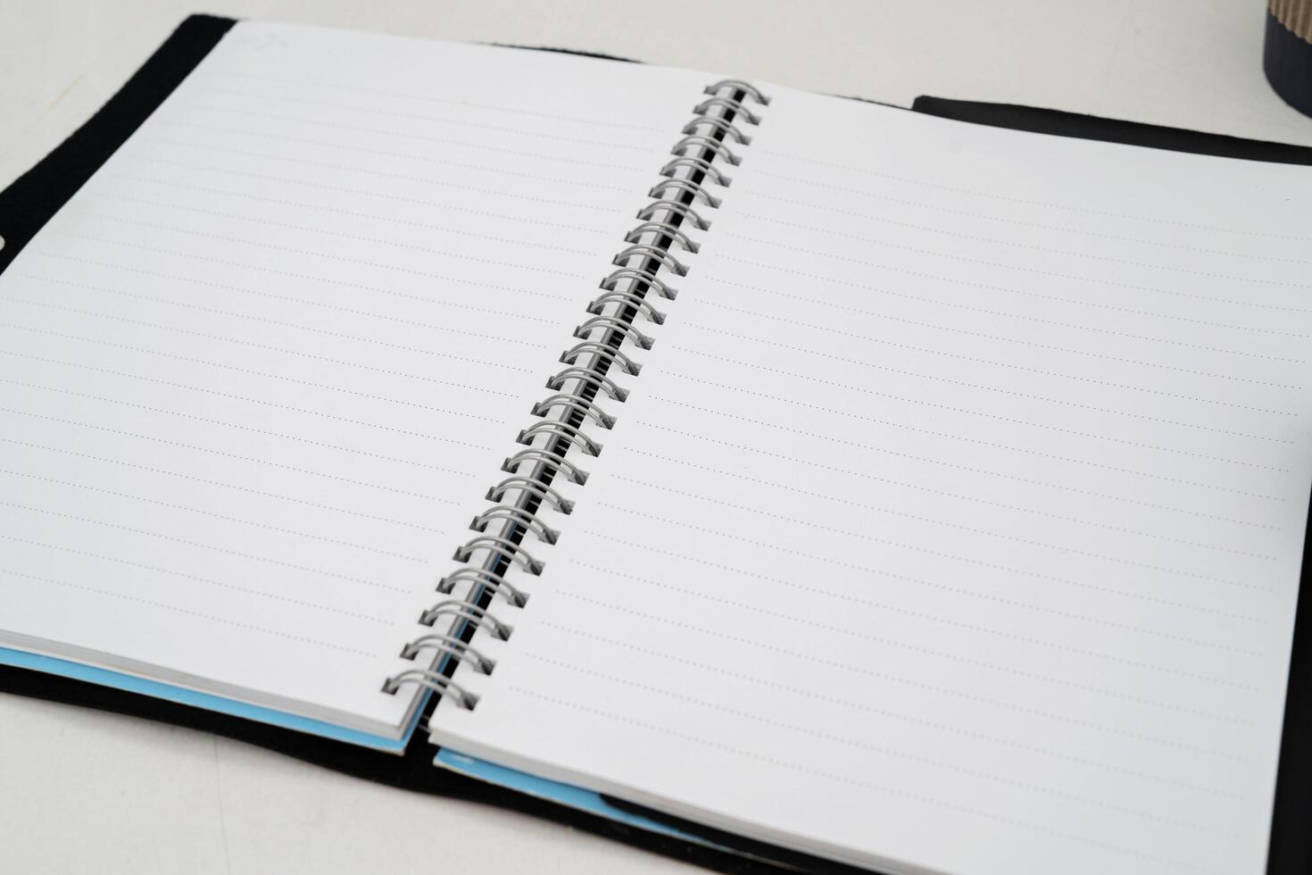Blank paper notebook on brown wooden table background. Top view with copy space photo