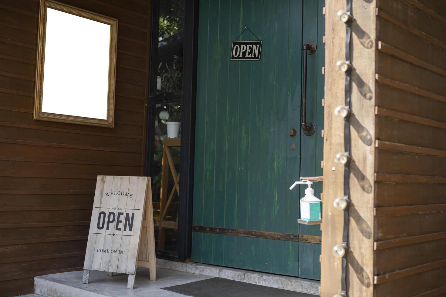 An opening metal sign on the floor in front of the coffee shop. Mockup Frame photo