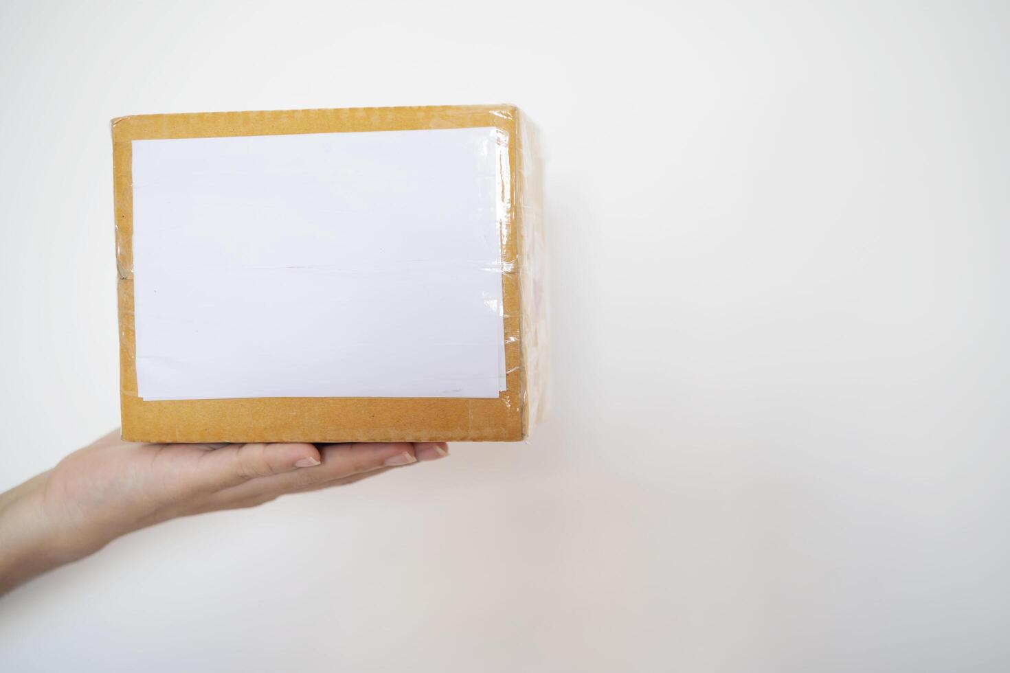 hand holding brown paper box package isolated on white background photo