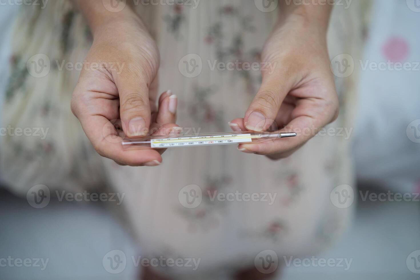 hand holding a digital thermometer. She has fever. photo
