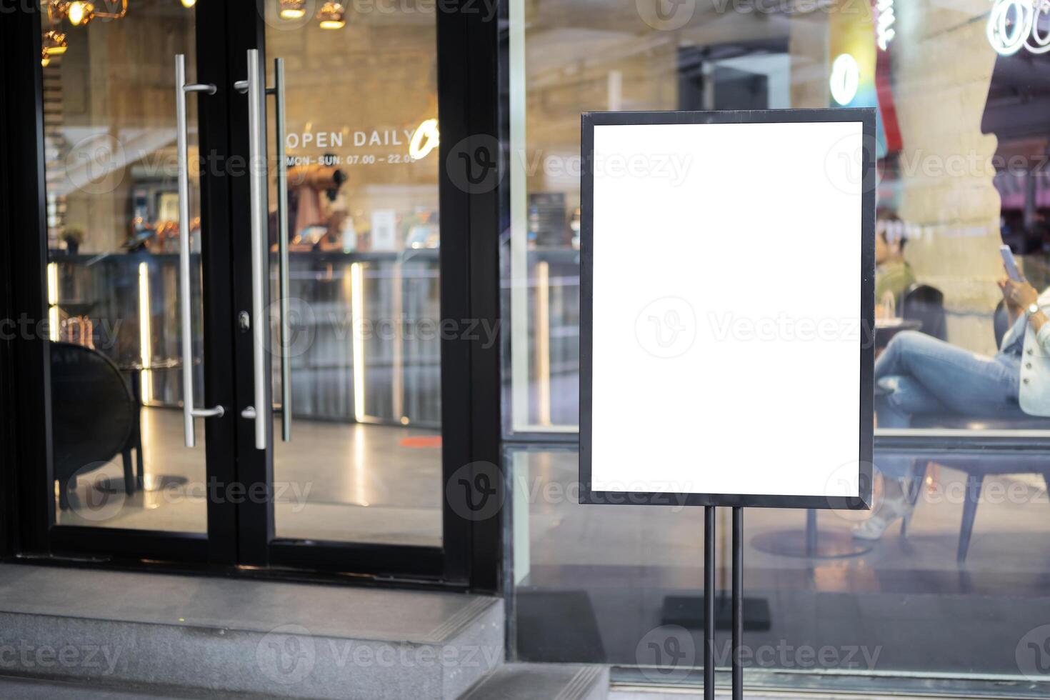 mockup white poster with black frame stand in front of blur restaurant cafe background photo