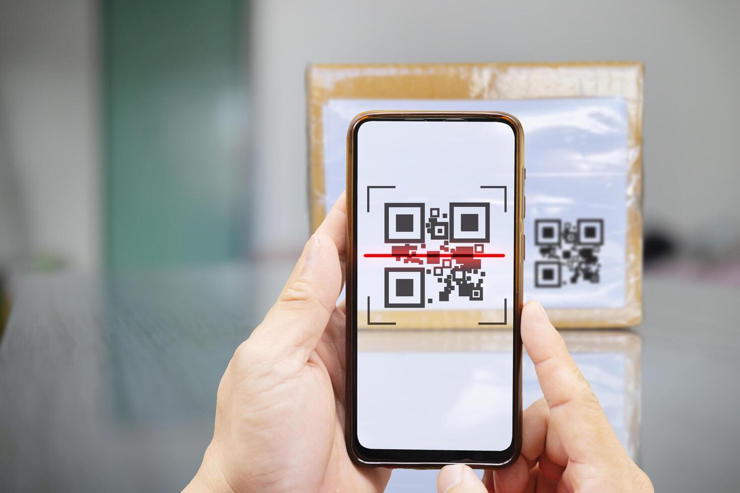 Modern stylish mobile phone scanning QR code on box. photo