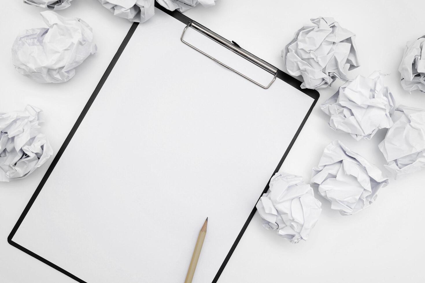 Total white monochromatic stationery flat lay. Notepad, white pencil and crumpled paper balls on white background. photo