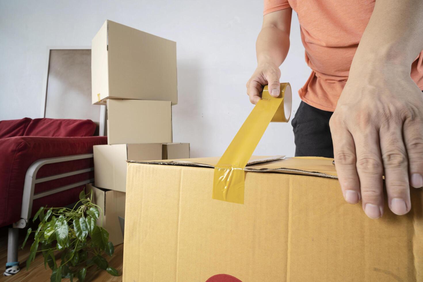 Closeup of man packing cardboard box, moving to a new house photo