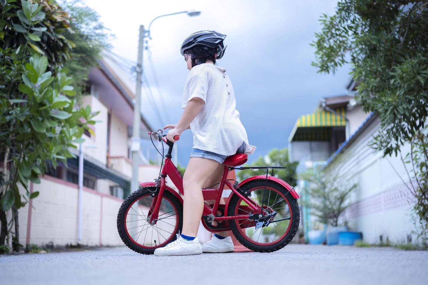Children learning to drive a bicycle on a driveway outside. photo