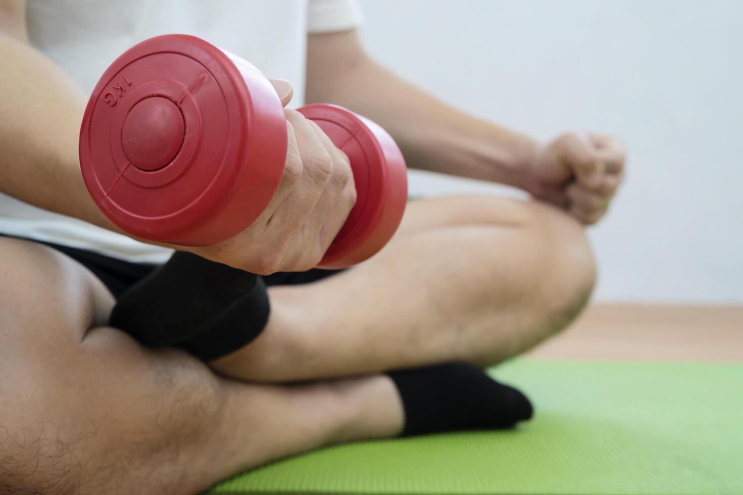Strong Athletic Fit Man in T-shirt and Shorts is Doing Calf Raise Exercises with Dumbbells at Home photo
