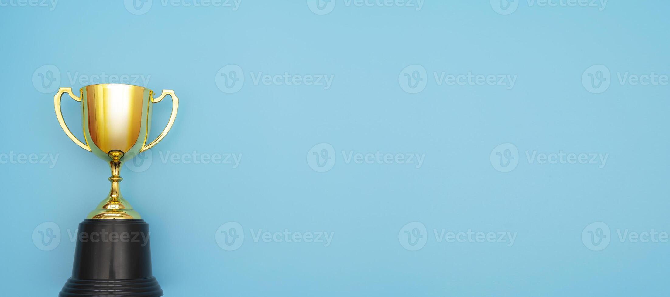 Simply flat lay design winner or champion gold trophy cup isolated on blue pastel colorful background. photo