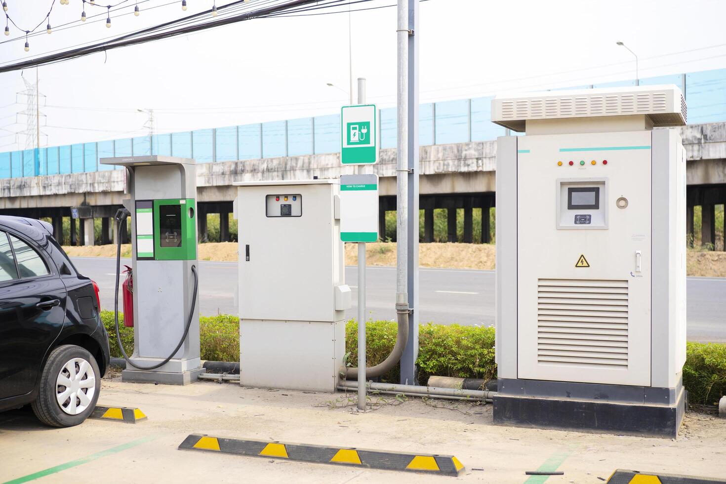 Electric car charging on parking lot with electric car charging station on city street. photo
