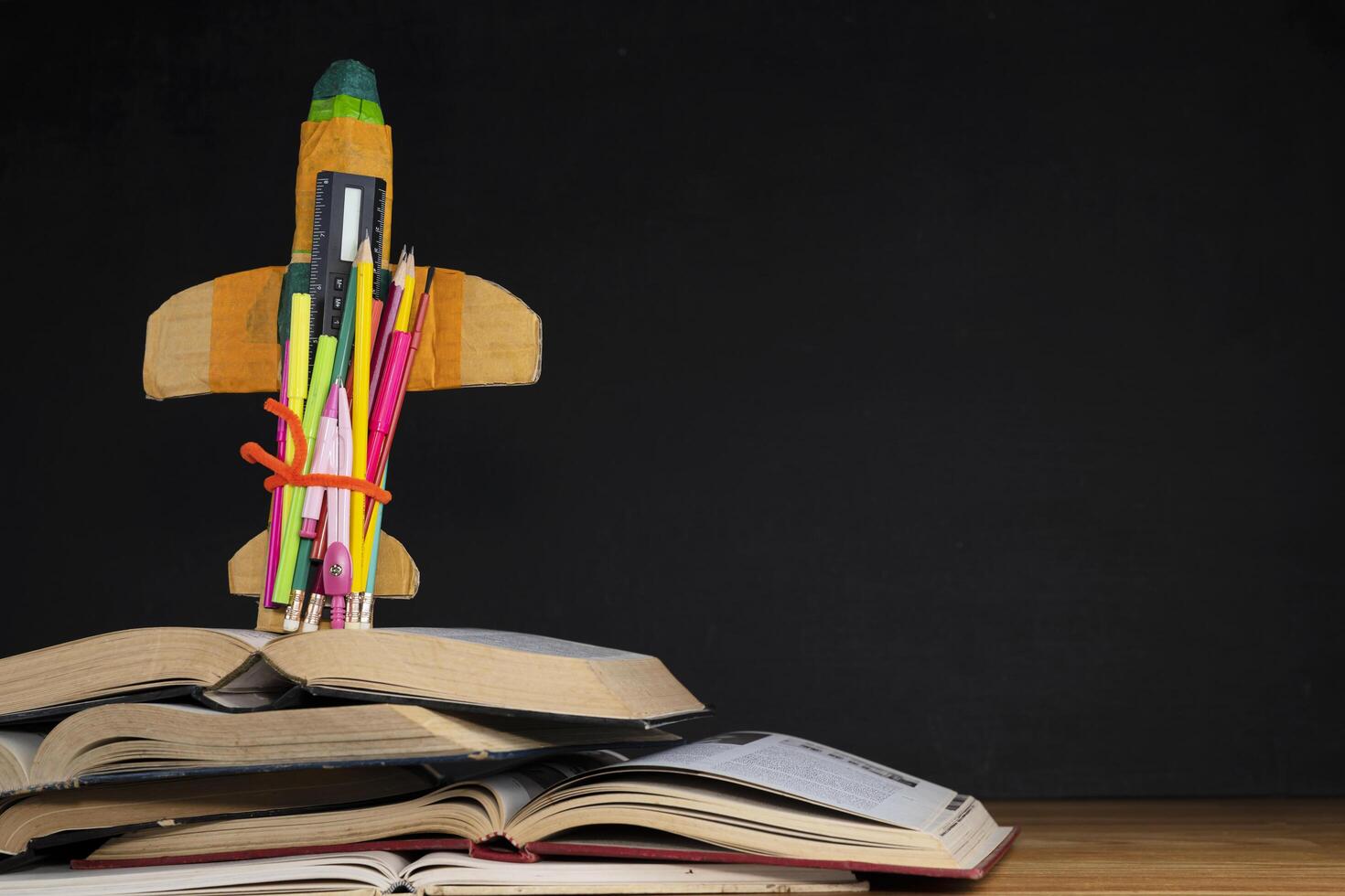 Creative Rocket With Colorful Pencils And Books On Desk - Back To School photo