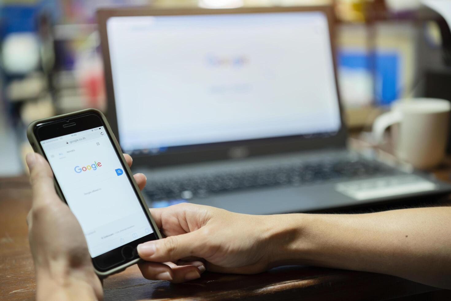 A woman is typing on Google search engine from a laptop photo