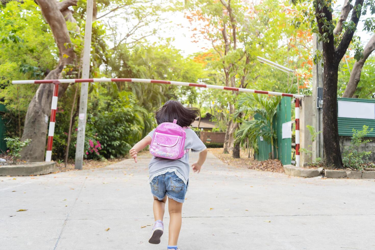 Cute asian child girl with backpack running and going to school with fun photo