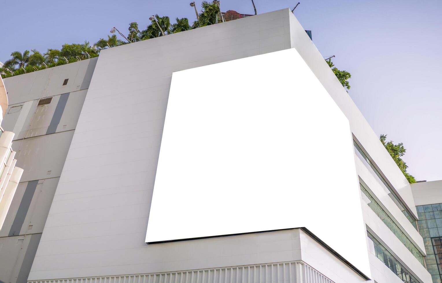 A large billboard installed in the corner of a large building. photo