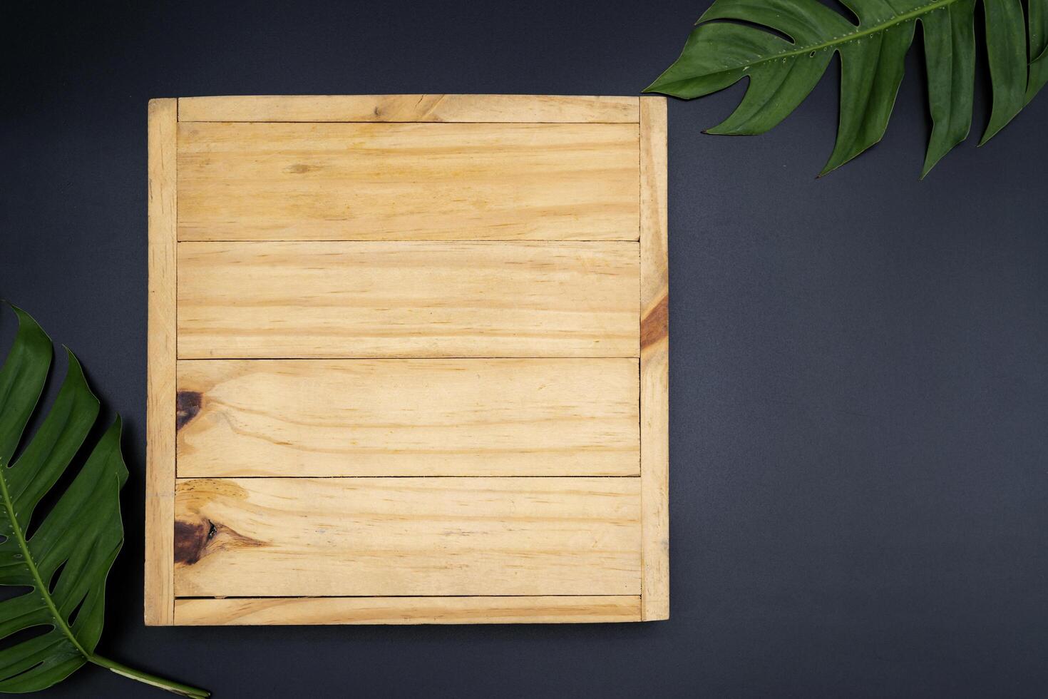 Top view of plank from dark wood, with frame from colorful autumn maple leaves. photo