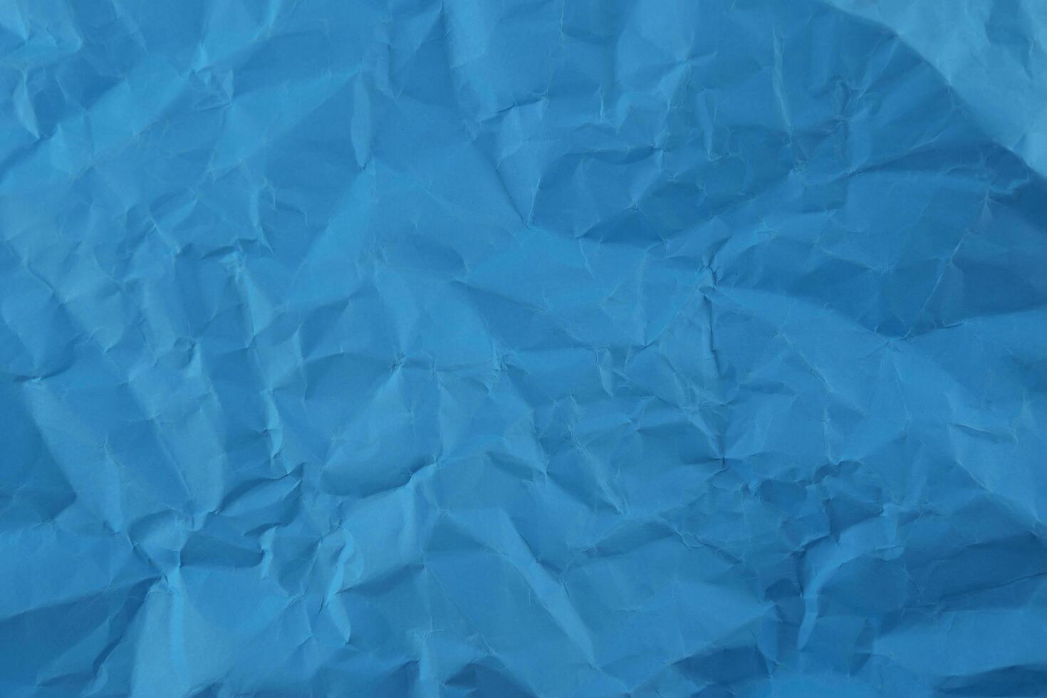 Wrinkled blue paper fragment as a background texture photo