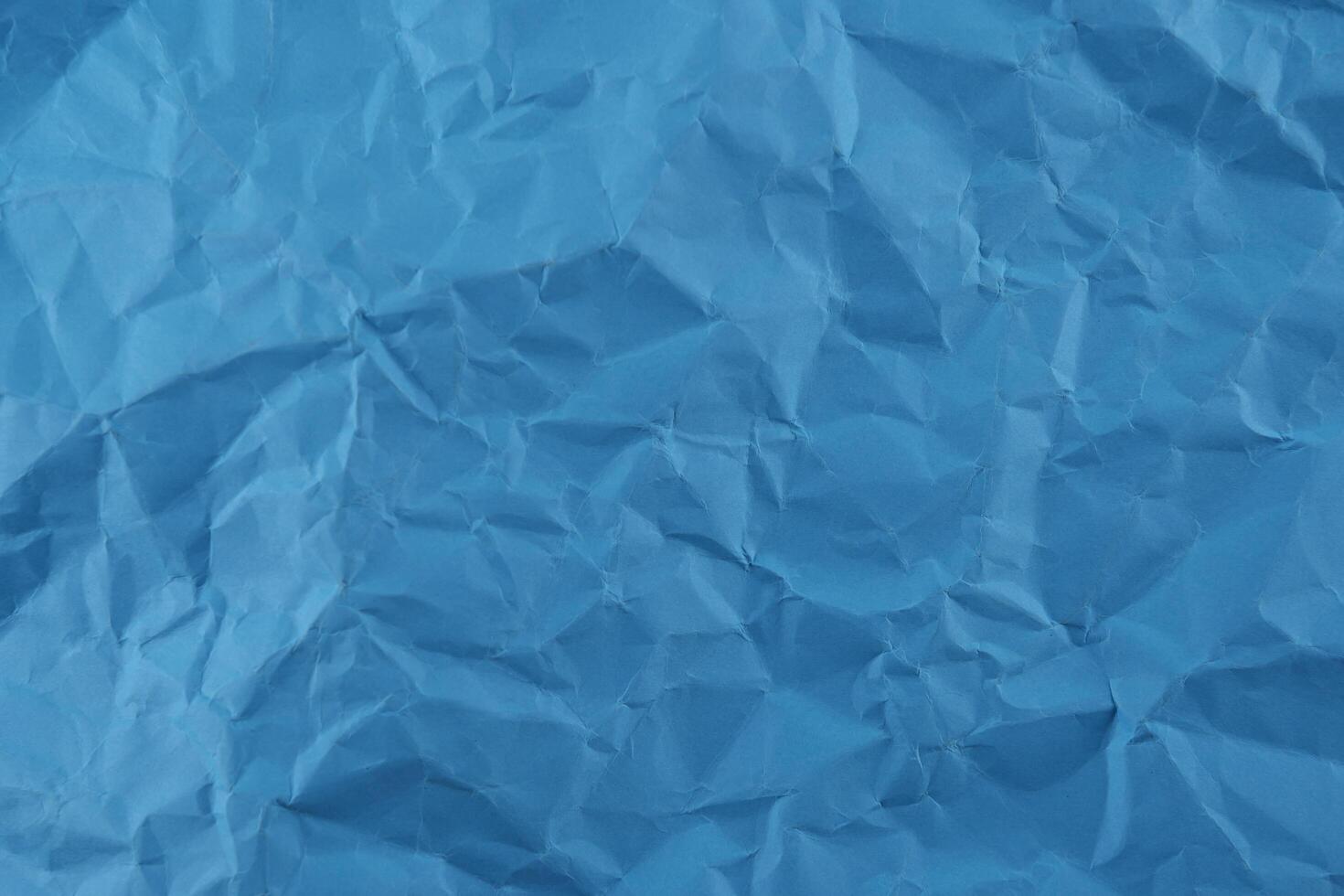 Blue crumpled paper texture background photo