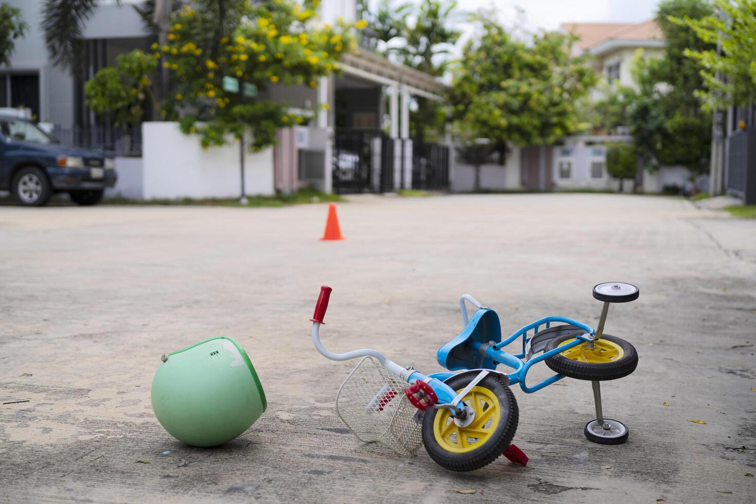 The child's small bicycle fell to the ground with a helmet photo