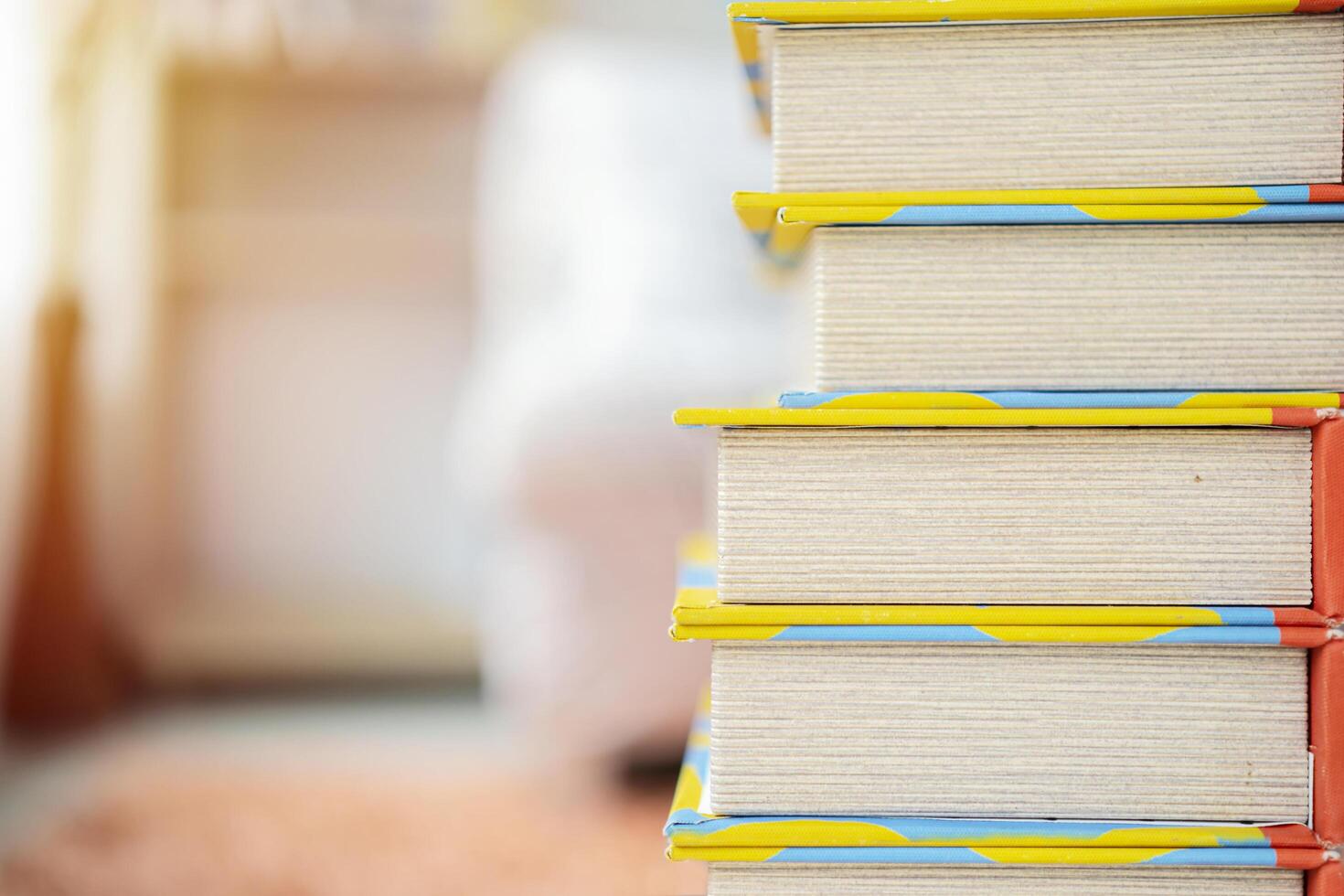 Book stack in the library room and blurred bookshelf for business and education background photo