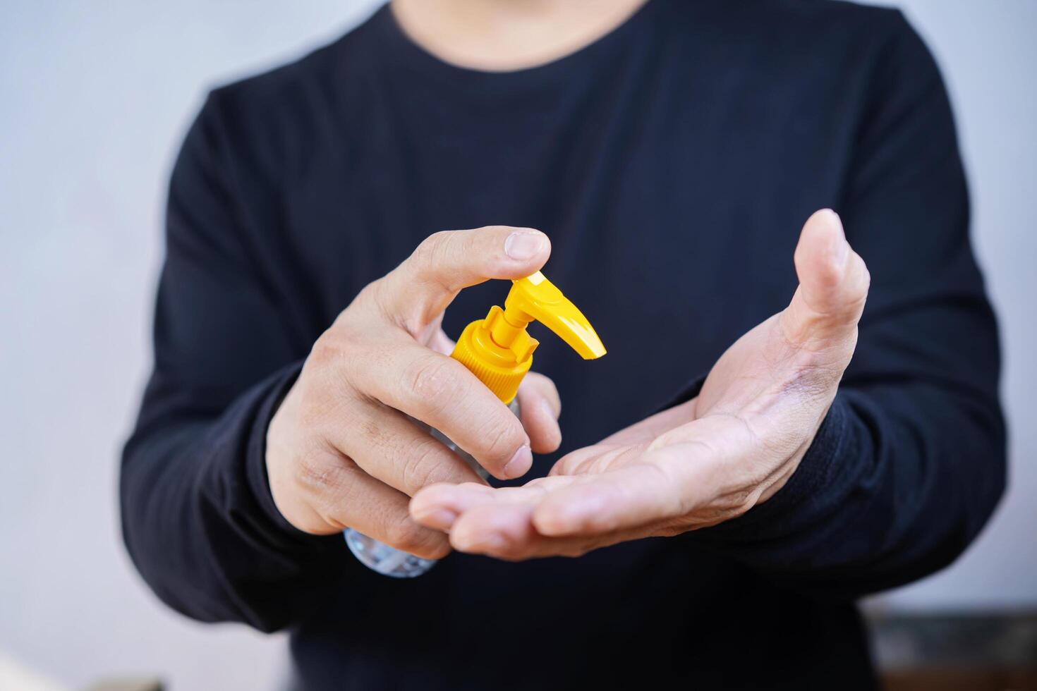 Antispetic sanitizer in hands. The man treats he hands with an antibacterial agent photo