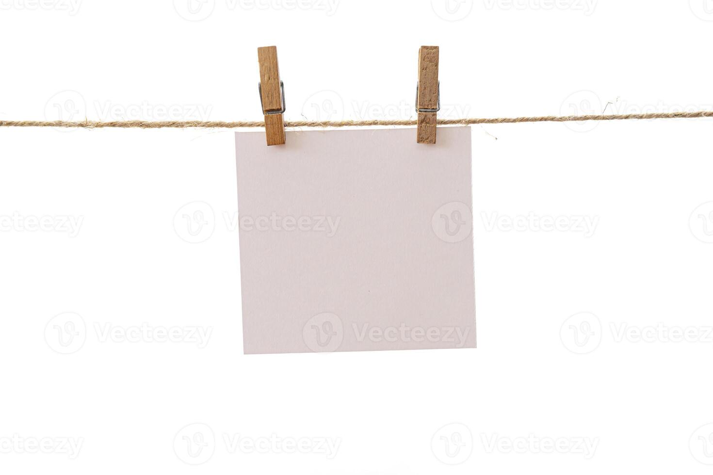Empty color paper sheets for notes, frames that hang on a rope with clothespins and isolated on white photo