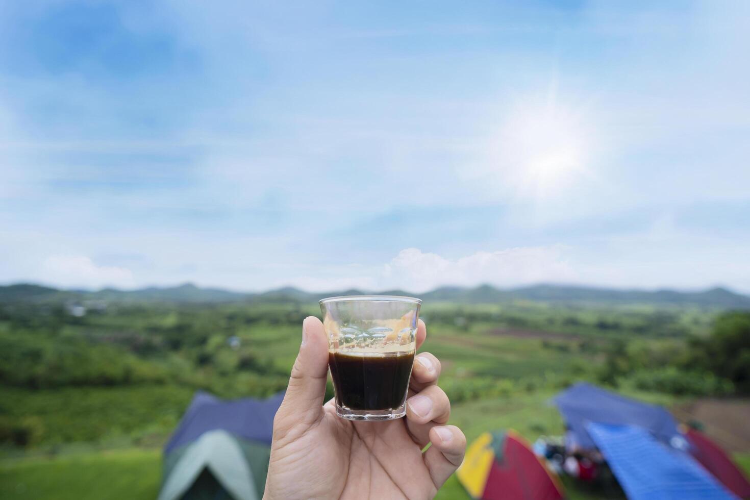 Man holding espresso coffee cup Looking at the beautiful natural mountain views photo