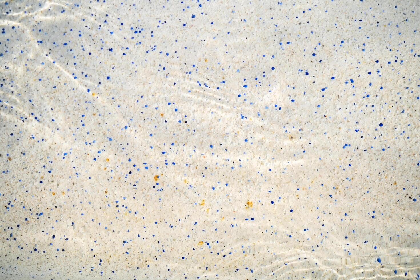 Tile floor of swimming pool with moving surface of chlorine water and reflection of sunlight photo