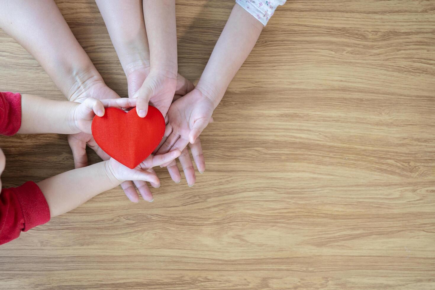 adult and child hands holding red heart on aqua background, heart health, donation, CSR concept, world heart day, world health day, family day photo