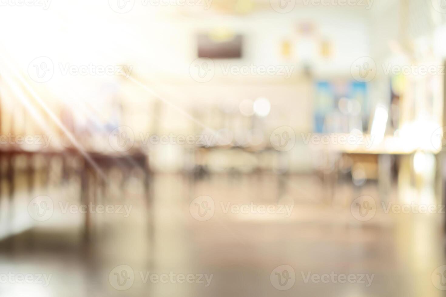 School classroom in blur background without young student Blurry view of elementary class room no kid or teacher with chairs and tables photo