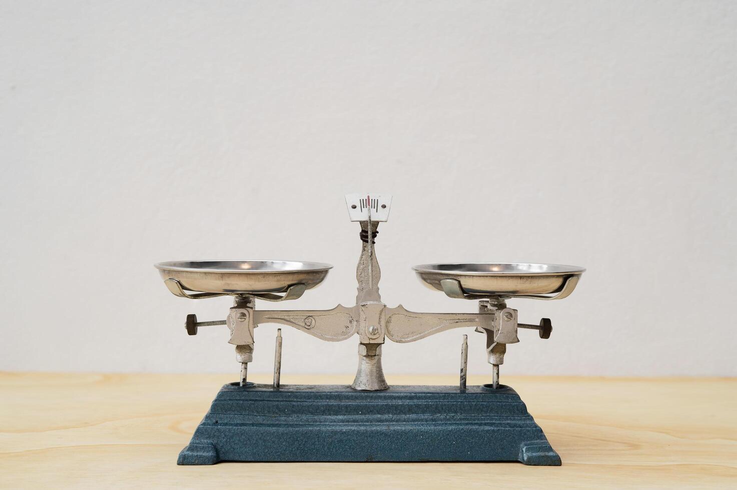 Antique vintage balance scales, Cast iron is placed on a wooden table on the background of a white wall. photo