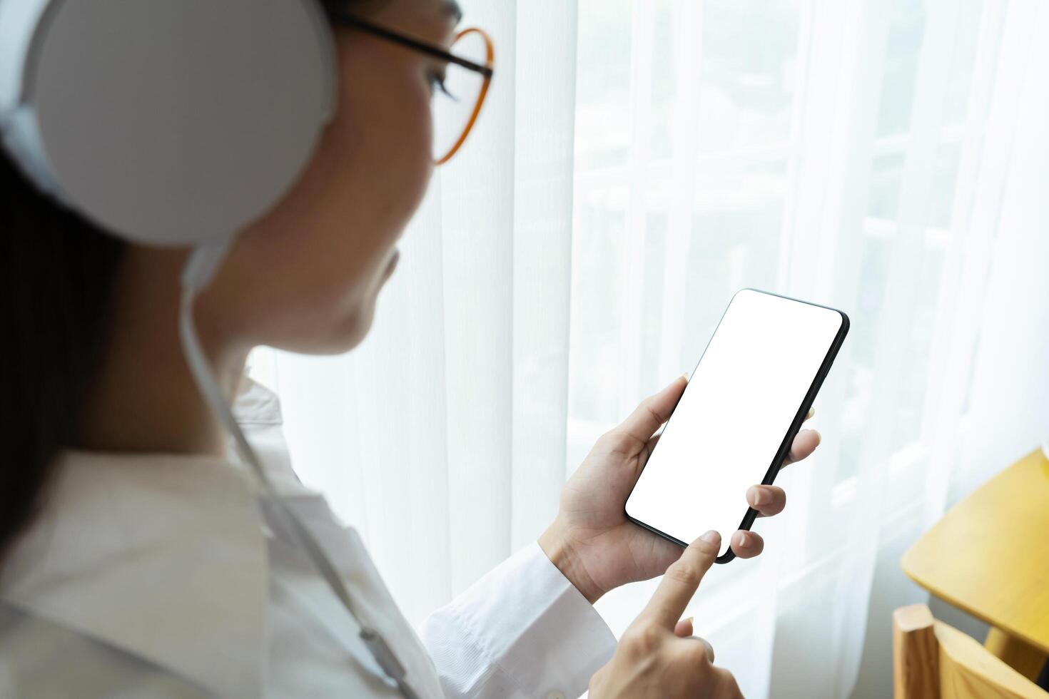 Beautiful Asian women listening to music with headphones and smartphones. A blank, white screen to enter ad text. photo