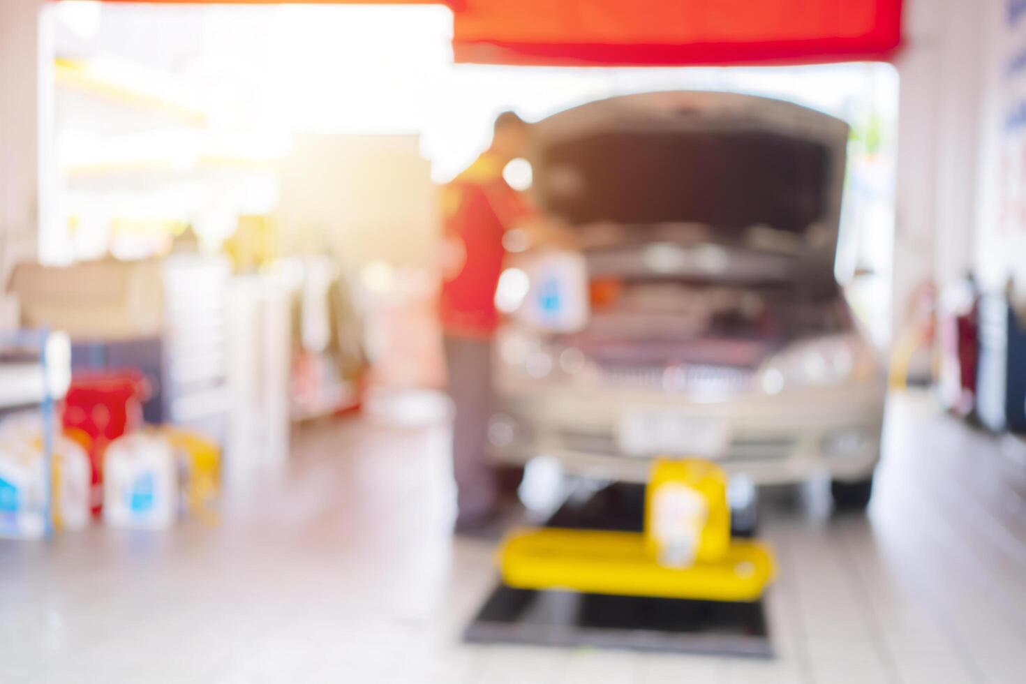 car service blurred, repair, maintenance concept - Asian auto mechanic man, technician doing the checklist for repair machine a car in the garage photo