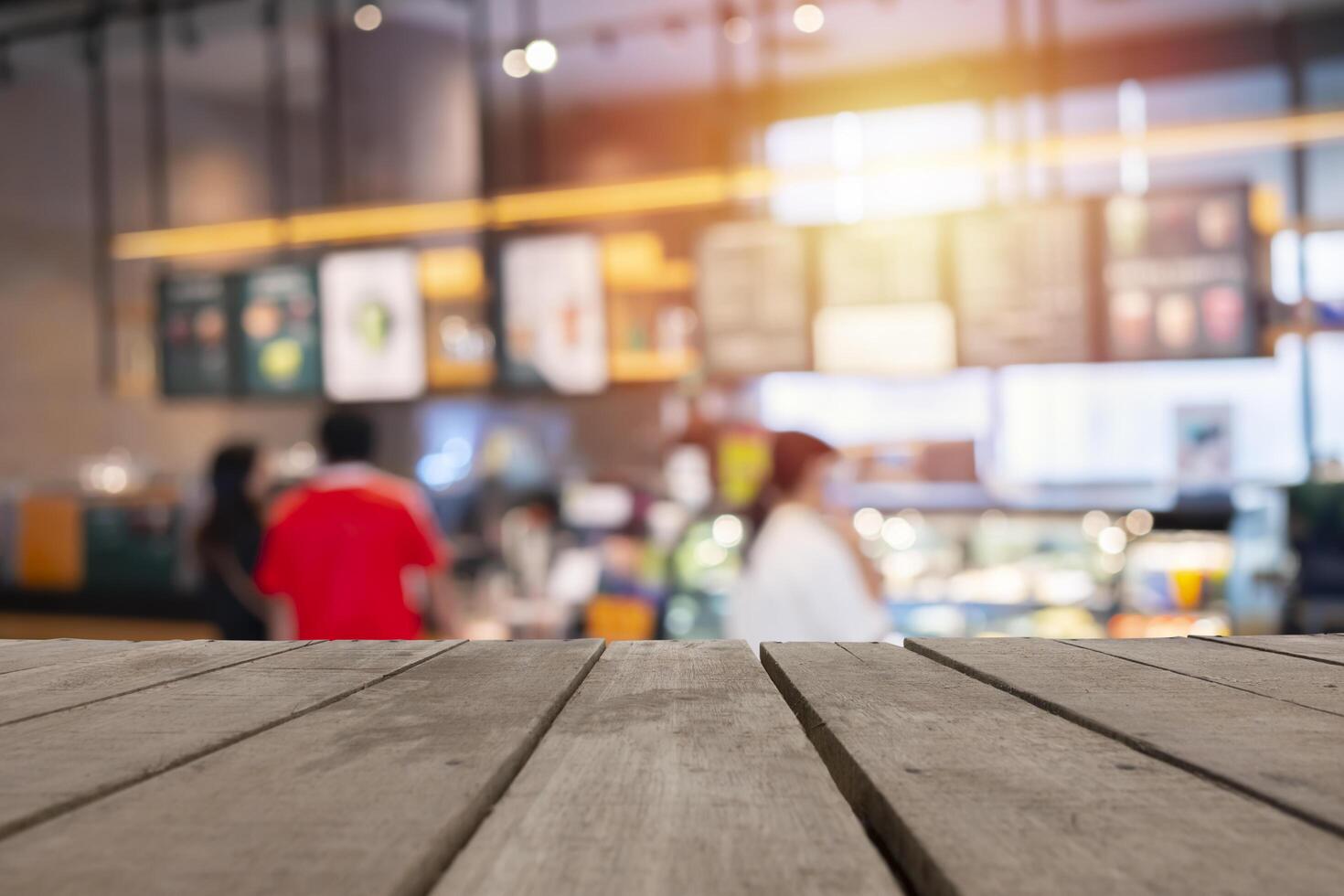 Wood table top background with blurred coffee shop and people sit on table blur background with bokeh image photo