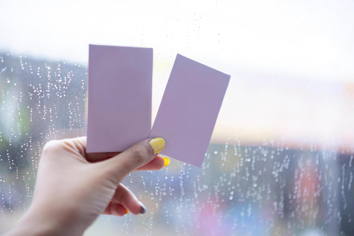 A woman's hand holding a blank pink paper postcard, so that it can put a message. photo