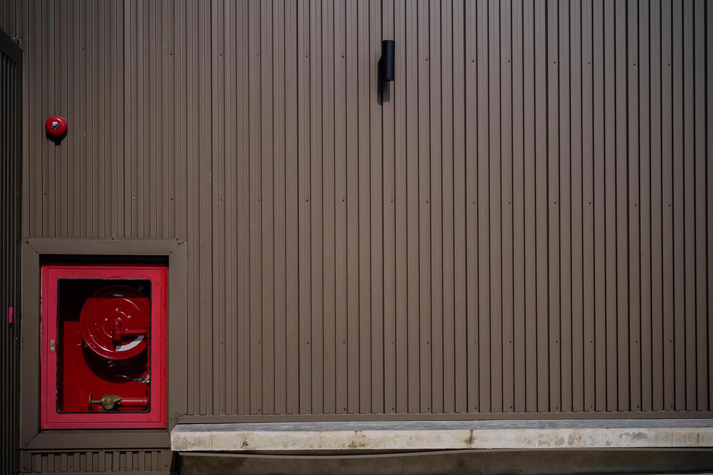 Fire hose hanging on the wall in the corridor, Electric alarm jingle photo