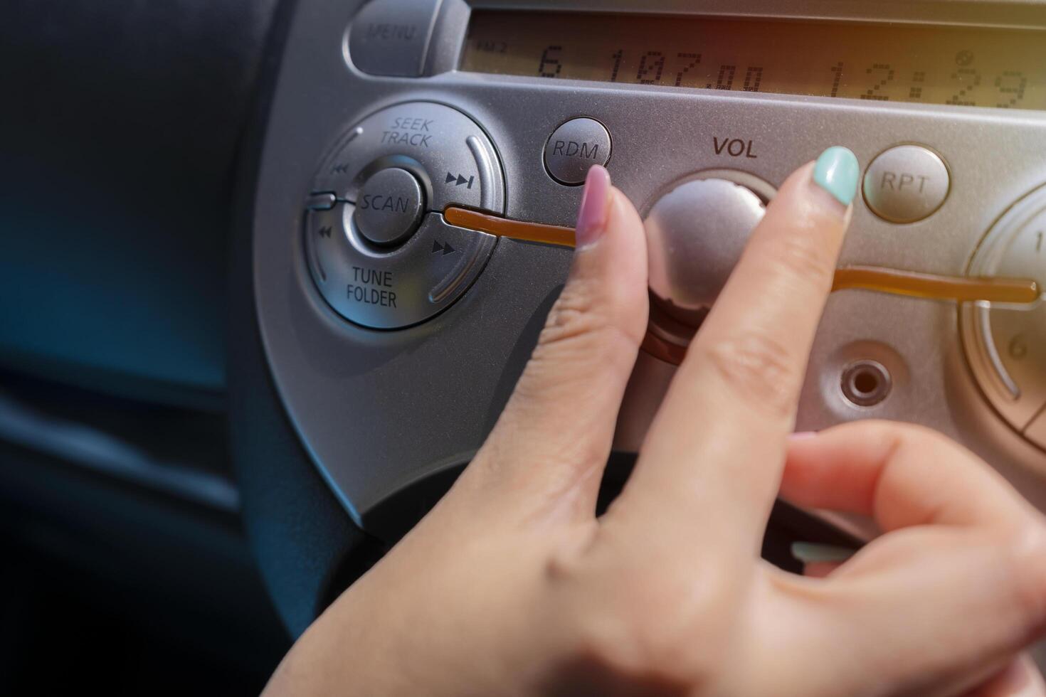 woman turning button of radio in car photo