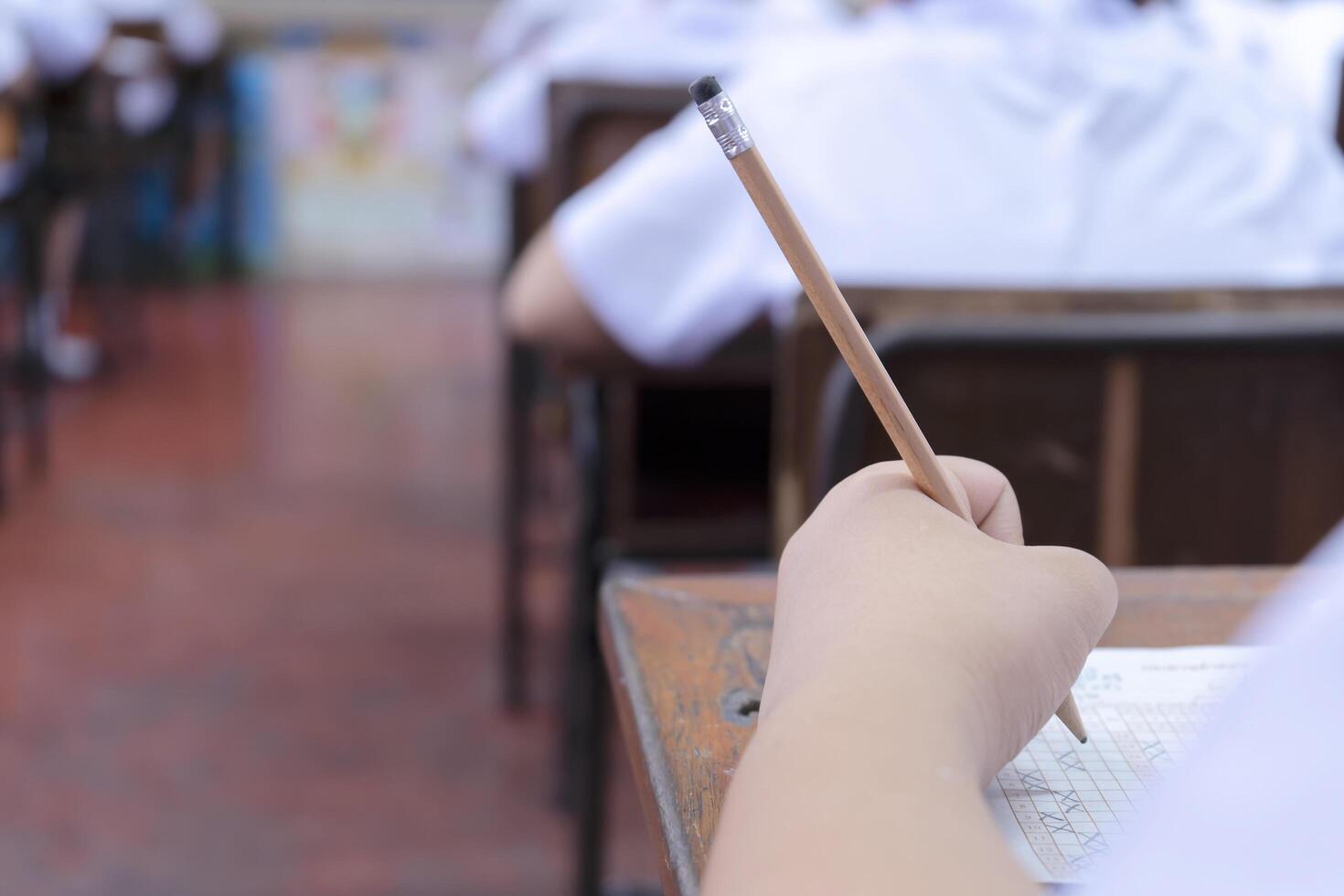 exams are placed on the table, Hand holding a pencil. photo