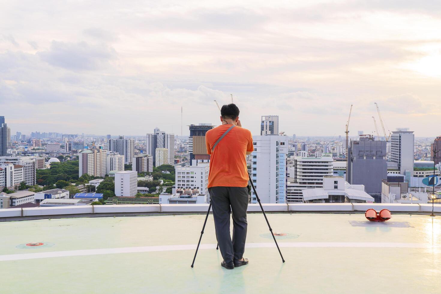 Take pictures using a tripod. Photographer intending to take pictures on the sky high rise building photo