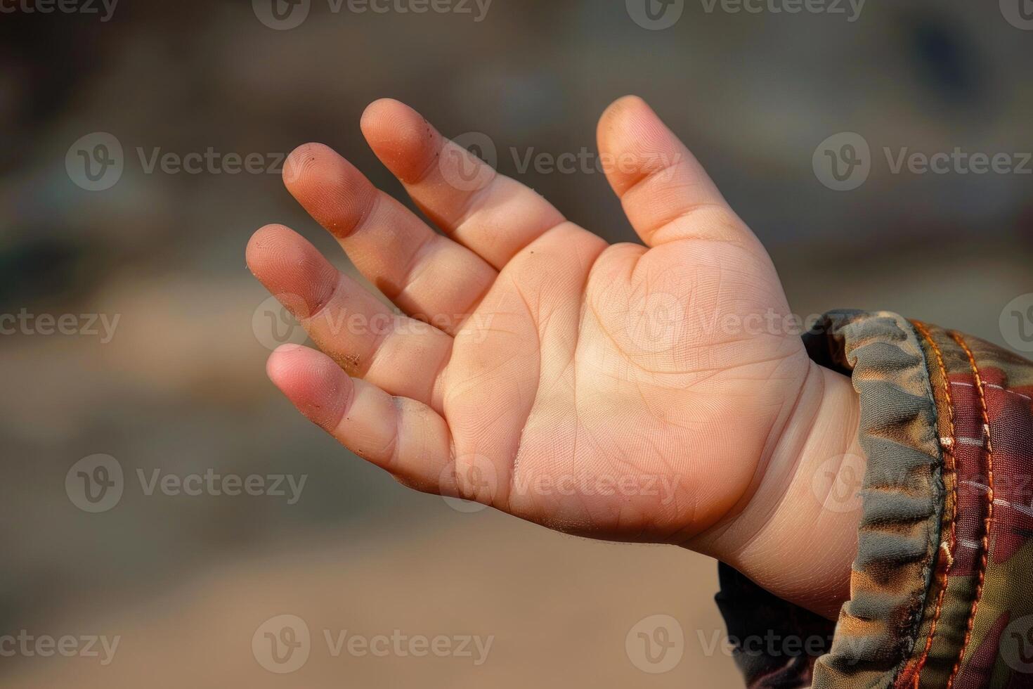 Toddler reaching out with open hand outdoors photo