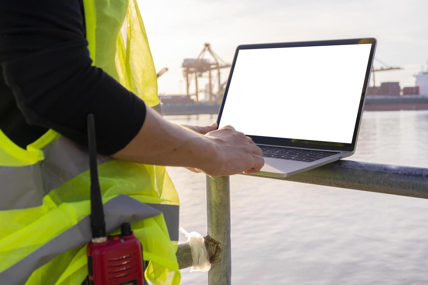 An engineer is using a tablet to work, she is at the shipping dock. Use radio communication for notifications and work orders. photo