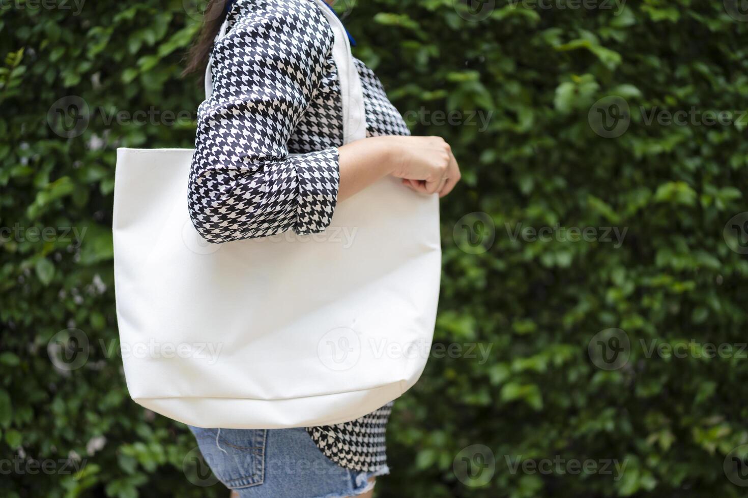 Asian girl is holding tote bag canvas fabric for mockup blank template photo