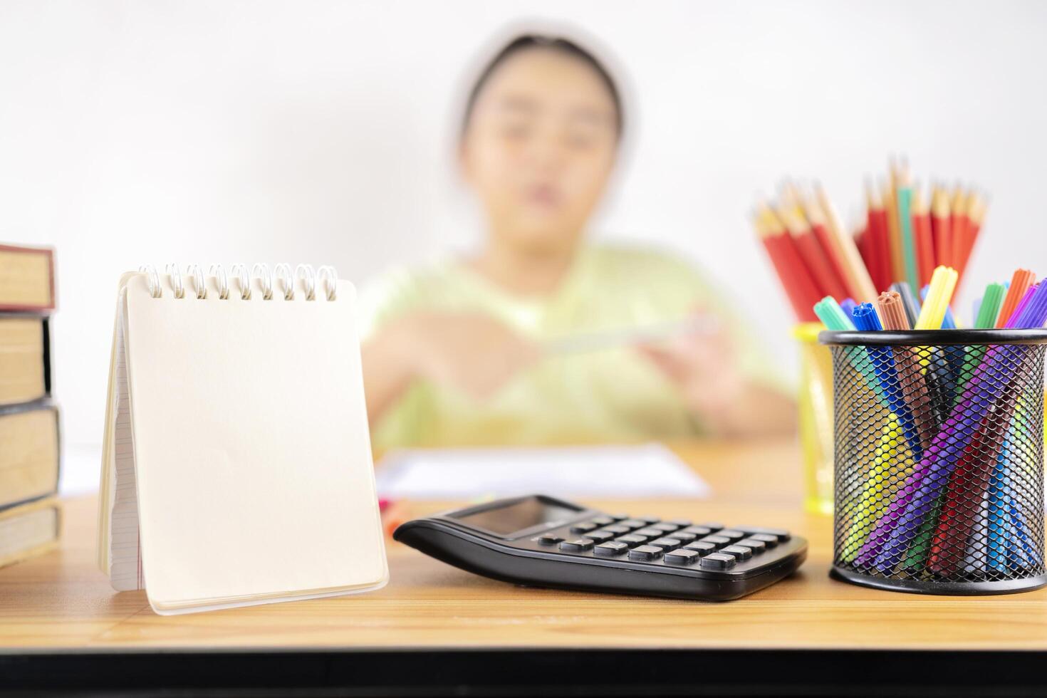 The next scene is a pencil box, calculator, blank notebook to put text photo