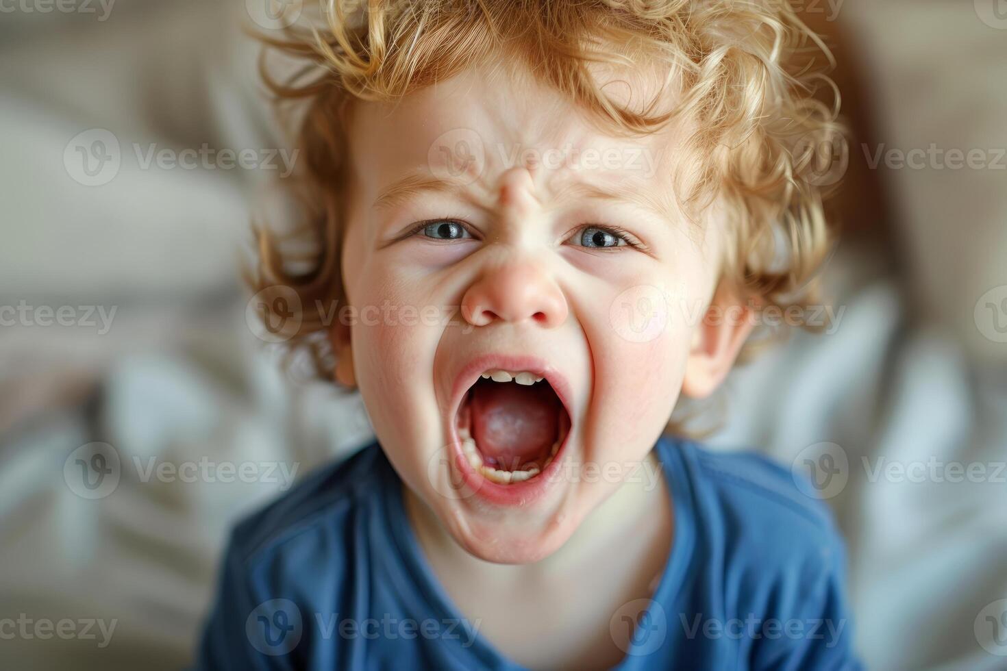 Closeup of a young boy screaming in frustration, expressing strong emotions photo