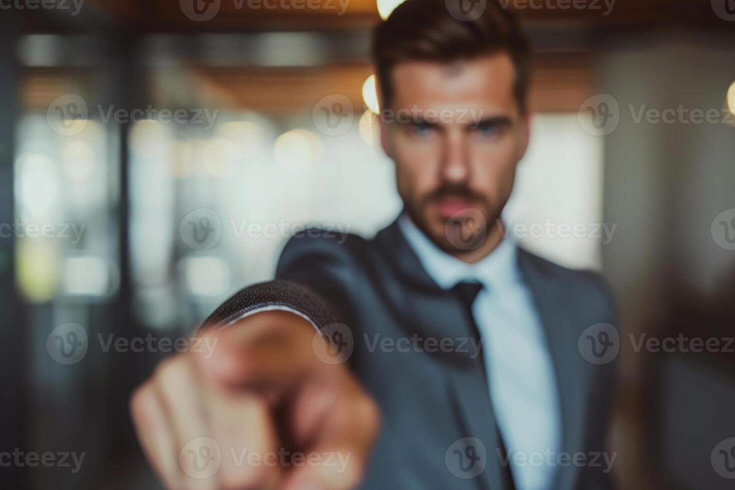 Blurred businessman pointing at camera photo