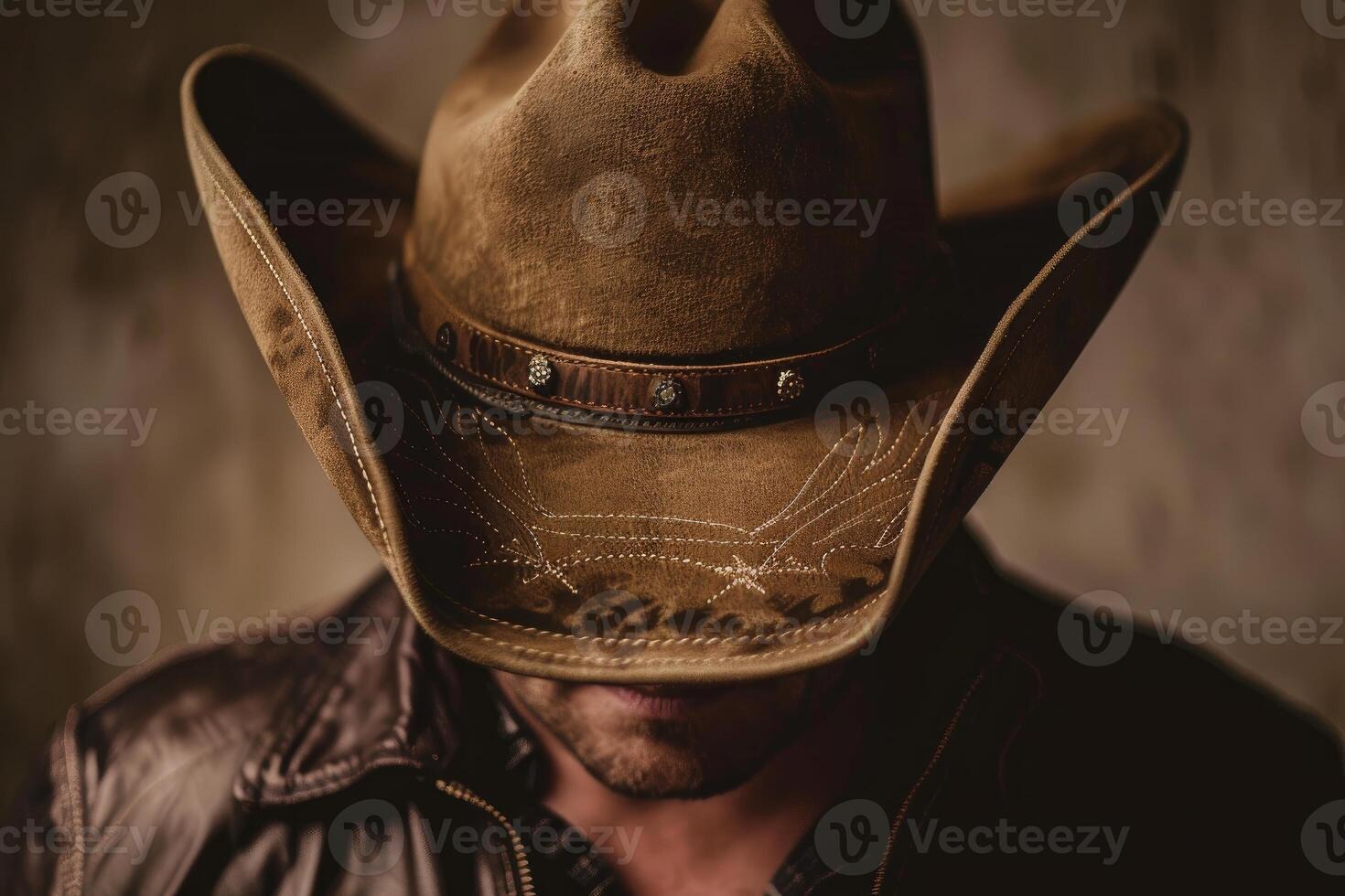 Closeup of an unrecognizable man wearing a cowboy hat, his face obscured by shadow photo