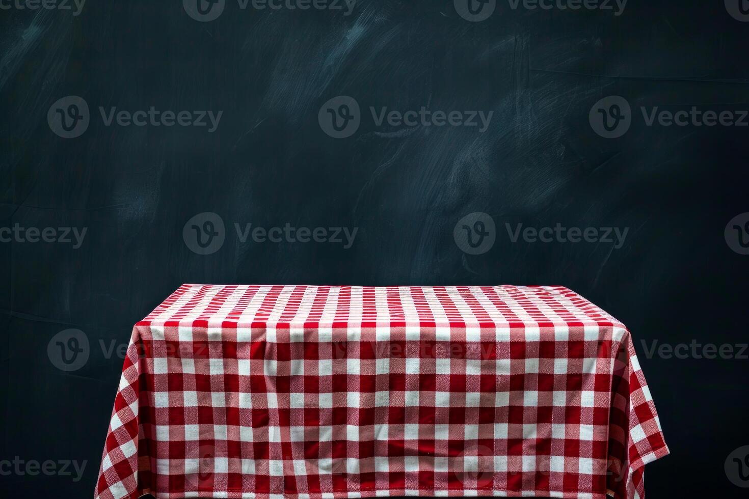 Red gingham tablecloth on empty table with chalkboard background photo