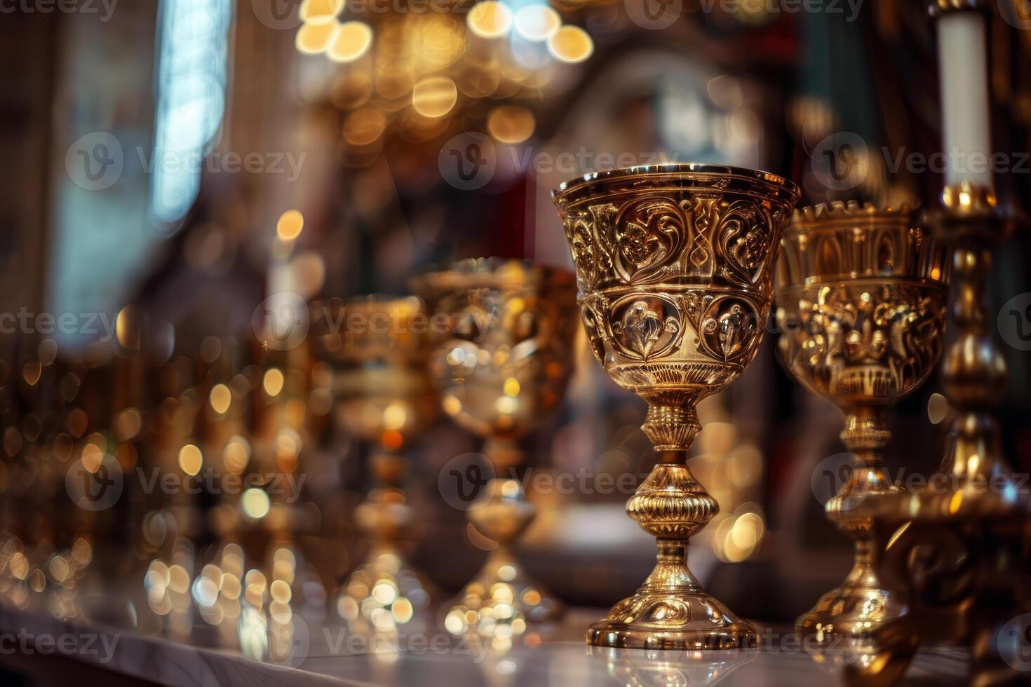 Golden chalices on display with intricate carvings photo