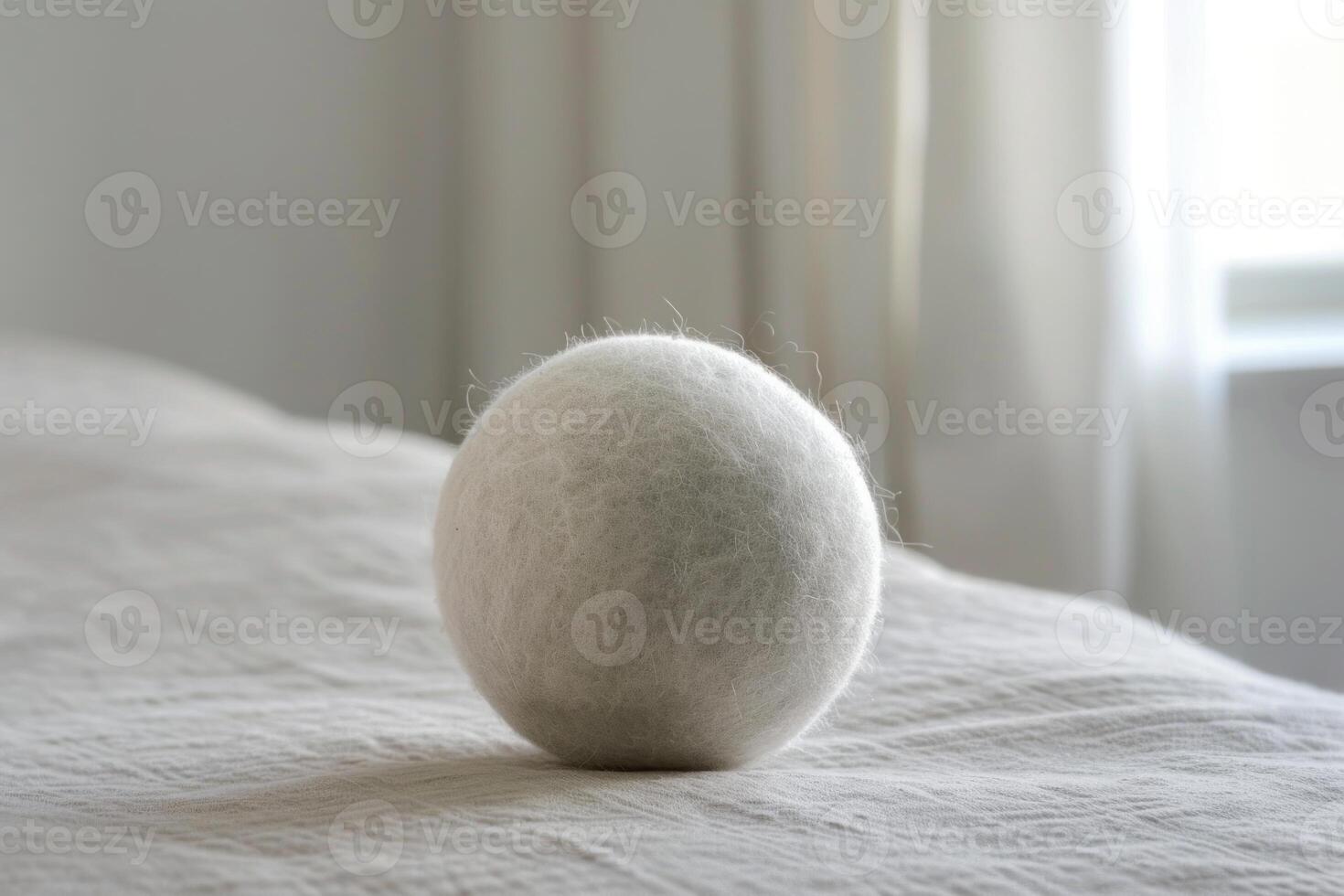 Wool dryer ball sitting on bed in bedroom photo