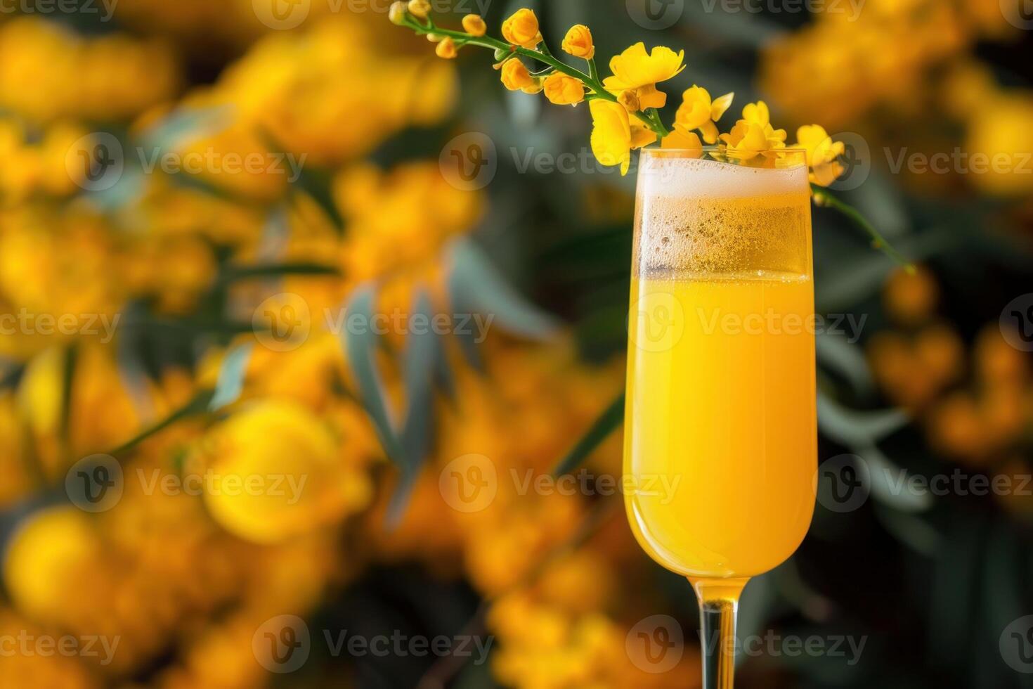 Mimosa cocktail standing near bright yellow flowers photo