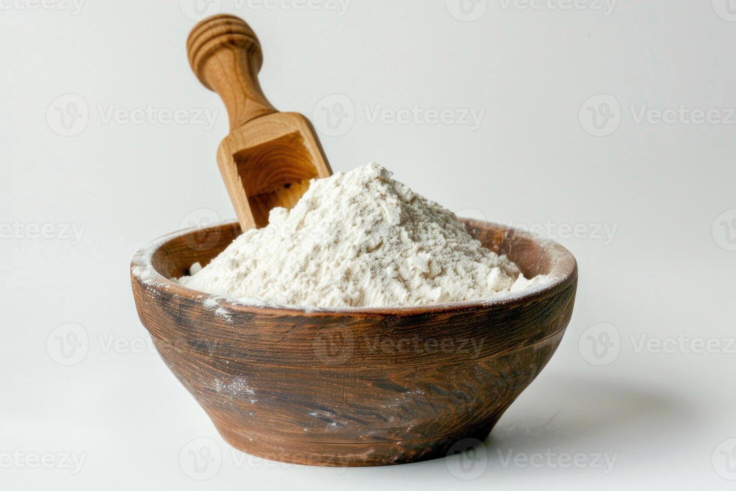 Wooden scoop resting on heap of flour in rustic bowl photo