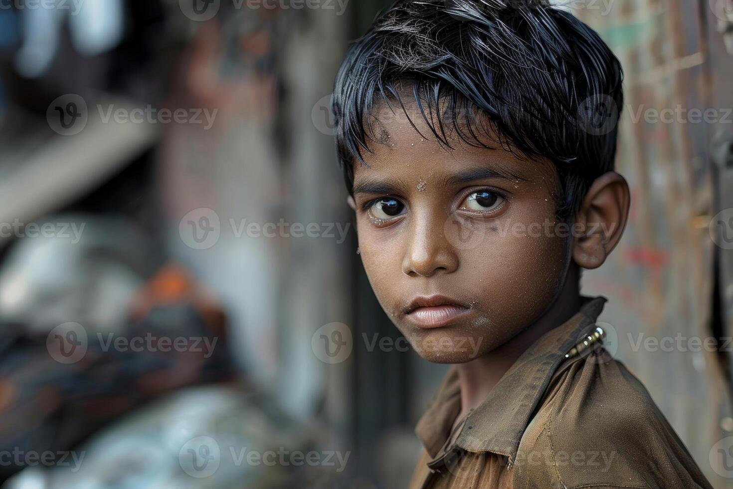 Young boy posing with a serious expression in a slum photo