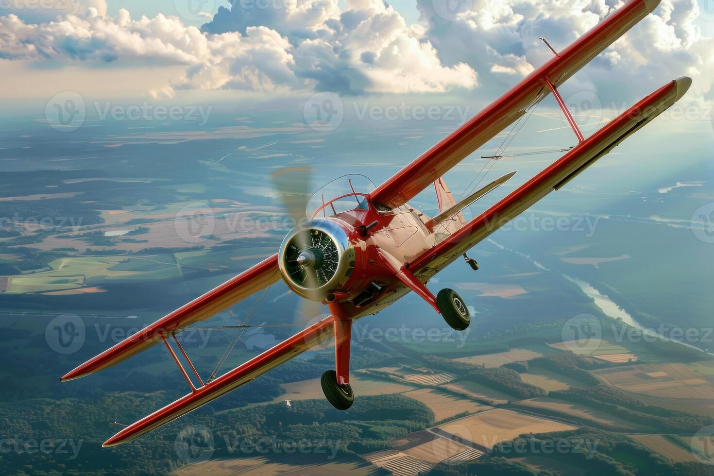 Red biplane flying over a river and countryside photo